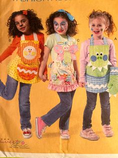 two girls in aprons and overalls with faces painted on them, standing next to each other