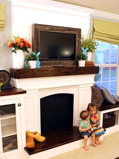 two children are sitting on the ledge of a fireplace