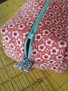 a red and white bag sitting on top of a cutting board next to a ruler