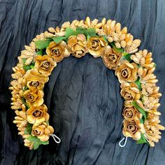 a wreath made out of gold flowers and leaves