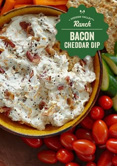 bacon cheddar dip in a bowl surrounded by vegetables and crackers