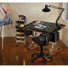 a desk with a chair and easel next to it in front of a brick wall