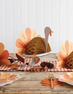 a table topped with plates and paper turkeys