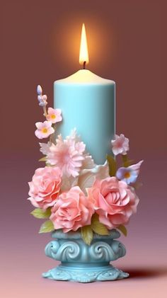 a blue candle with pink flowers in it