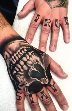 two hands that have tattoos on them and one has a skull in the middle of it