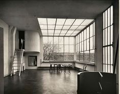 an empty room with large windows and tables