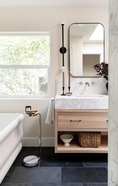 the bathroom is clean and ready to be used as a bathtub, sink, and mirror