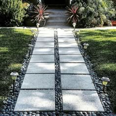 a walkway made out of stones leads to a house