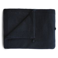 a black blanket folded on top of a white surface