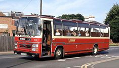 a red and white bus driving down the street