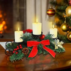 a christmas wreath with candles and decorations on a table