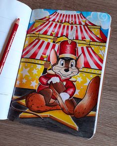 an open book with a drawing of a cartoon mouse on the cover and a pencil next to it