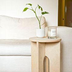 a small table with a vase on it next to a couch