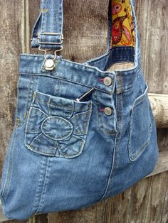 an old pair of blue jeans hanging on a wooden fence with the bottom pocket open