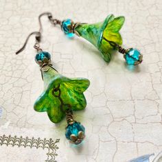 Adorable iridescent Green Flower Earrings, these colourful hand painted green flowers hang from filigree flute bead caps, they are finished with little crystals that are so eye catching and sparkly. These earrings are one of a kind and would make the most luxurious gift. Matching necklace available here: https://etsy.me/338DbVC ▪️ One of a kind, only one made. ▪️ lightweight and comfortable. ▪️ This item is ready for posting. ▪️ Lead and Nickel free components. ▪️SIZE: approximately 50mm. ▪️MATE Green Fairy Earrings, Big Funky Earrings, Funky Earrings Diy, Green Flower Earrings, Jewellery Diy, Earrings Funky, Green Fairy, Hand Painted Earrings, Iridescent Green