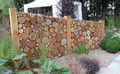 a wooden fence made out of logs in a garden