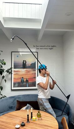 a man standing on top of a blue couch holding a fishing pole