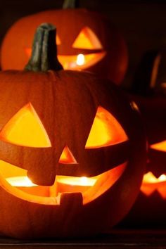 several carved pumpkins with glowing faces on them