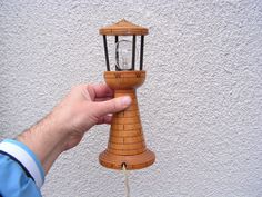 a hand is holding a small wooden light