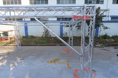 an outdoor stage set up in front of a building with orange hoses on the ground