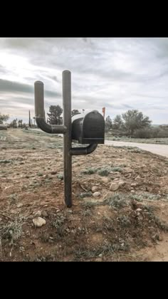 a mailbox sitting on top of a dry grass covered field