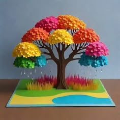 a pop up card with a tree made out of colorful paper flowers and water drops