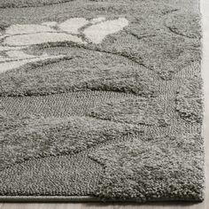 a gray rug with an abstract design on the bottom and white accents in the middle