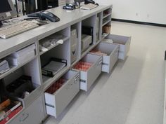 an office cubicle with many drawers and computer equipment