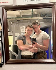 a man and woman taking a selfie in front of a mirror with their arms around each other