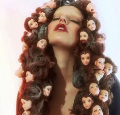 a woman with long hair and many dolls on her head is shown in this image