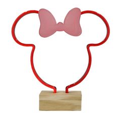 a red mickey mouse head with a pink bow on it's head and a wooden base