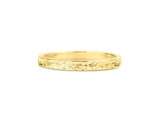 a yellow gold wedding ring with leaves on the sides and an engraved design in the middle