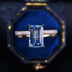 an engagement ring with a blue topazte surrounded by diamonds