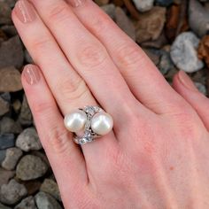 This magnificent vintage ring features a by-pass design and is accented with two (2), post set, cultured South Sea pearls, one (1), channel set, baguette cut diamond, one (1), prong set, half moon step cut diamond, one (1) trapezoid step cut diamond and four (4), bead set, round brilliant cut diamonds. The ring measures 17.6mm at the top, rises 11.5mm above the finger, tapering to 1.8mm wide and 1.2mm thick at the base of the shank. It is a size 6.25. The half-moon cut diamond has a small chip that cannot be seen without jewelers magnification. Elegant Multi-stone Diamond Wedding Ring, Elegant Polished Bypass Ring For Anniversary, Multi-stone Diamond Pearl Ring For Wedding, Elegant Multi-stone Pear-shaped Diamond Ring, Heirloom Multi-stone Pearl Ring For Anniversary, Elegant Multi-stone Diamond Anniversary Ring, Elegant Multi-stone Diamond Ring For Anniversary, Elegant Oval Bypass Ring For Formal Occasions, Elegant Formal Multi-stone Pearl Ring