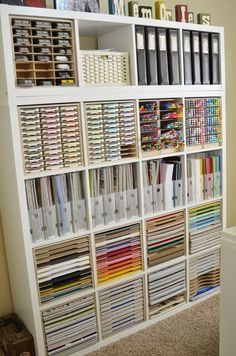 a bookcase filled with lots of books next to a wall full of binders