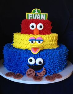 a three tiered cake made to look like sesame street characters