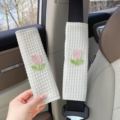 two white towels with pink flowers on them sitting in the back seat of a car