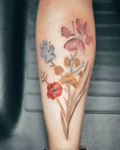 a close up of a person's leg with flowers on it