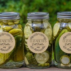 three jars filled with pickles and cucumbers