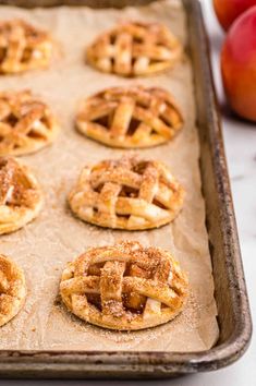 apple pies on a baking sheet ready to be baked in the oven for dessert