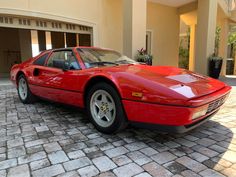 a red sports car parked in front of a house