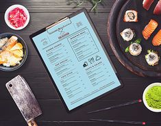 an overhead view of sushi and chopsticks on a table with a menu