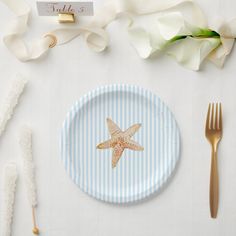 a plate with a starfish on it next to utensils and napkins