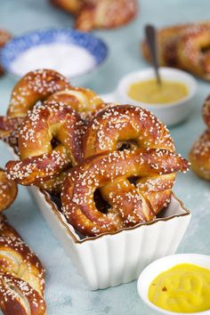 some pretzels are sitting in a small white dish with sesame seeds on top