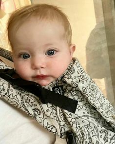 a baby wearing a black and white shirt with a bow tie on it's neck