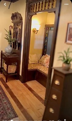 a mirror sitting on top of a wooden floor next to a table and chair in a living room