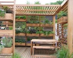 a wooden pergoline with benches and plants growing on the sides, surrounded by greenery