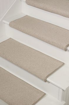 three beige carpeted steps leading up to a white door