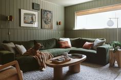 a living room filled with furniture and a dog sitting on the couch