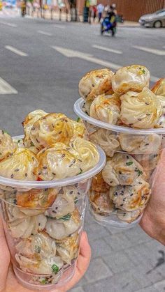 two people holding plastic cups filled with food